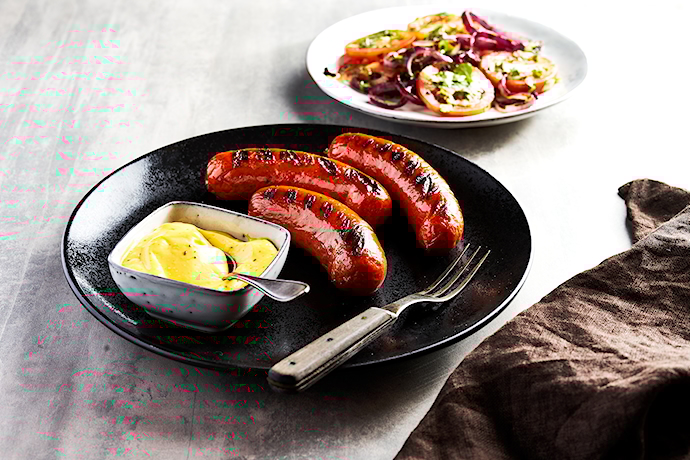Grilled Carlos sausage with red onion and tomato salad